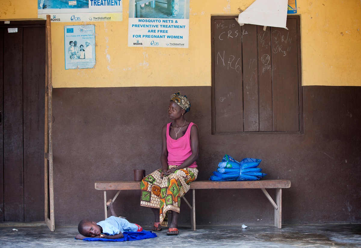 Digba Massaquoi waits with her 5-year-old son, Lahai, who is ill, at the health clinic in Benduma, outside Bo, Sierra Leone. Beside her on the bench are insecticide-treated mosquito nets provided by the United Methodist Church's Imagine No Malaria initiative as part of an integrated health campaign during Sierra Leone's national Maternal and Child Health Week. Photo by Mike DuBose, UMNS. 
