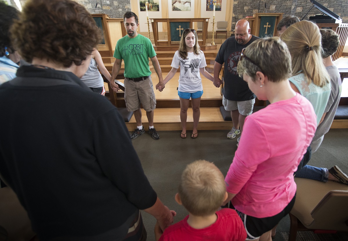 The Rev. Paul Bonner (at rear in green shirt) leads a prayer service at Christ United Methodist Church in Franklin, Tenn., to lift up those facing the Ebola crisis in West Africa. Bonner, youth minister at the church, helped lead a 2013 mission team to Sierra Leone. 