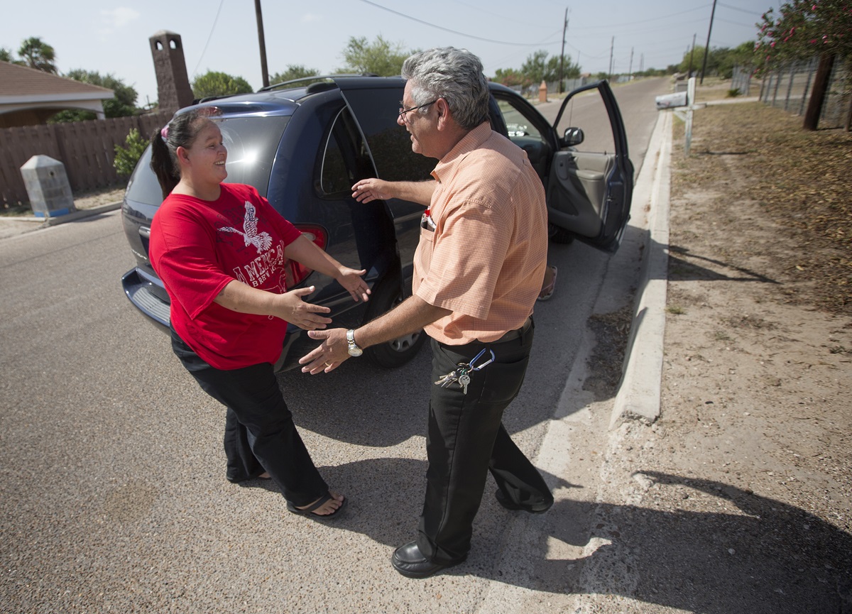Sanuanita Leal (left) greets the Rev. Javier Leyva near her home in Mission, Texas. Leyva, now director of immigration ministries for The United Methodist Church in South Texas, previously served as her pastor and baptized Leal and her family.