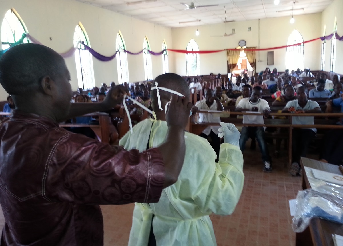 Mohamed Kamara, United Methodist health care worker and facilitator, demonstrates how to use personal protective equipment during training.