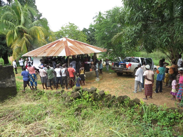 People in Mongere, Sierra Leone,  gather around the village hut to hear an educational message about Ebola from The United Methodist Church in Sierra Leone. Photo by Phileas Jusu, UMNS.