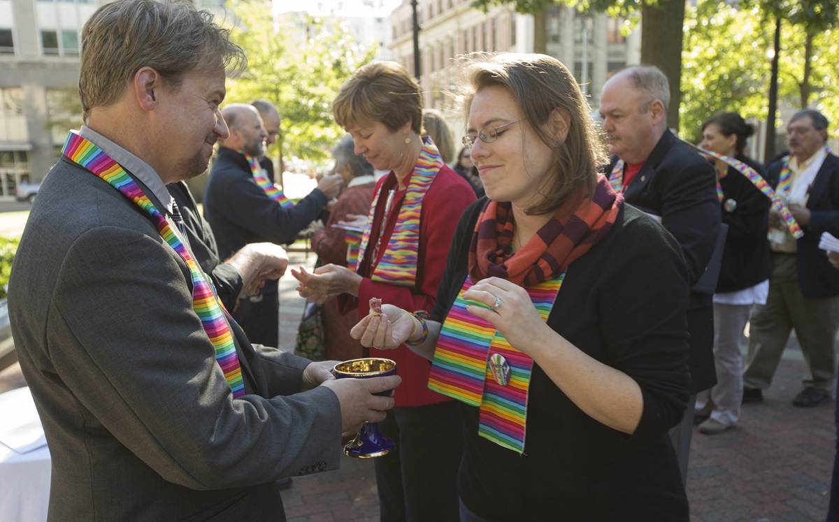 The Rev. Frank Schaefer (left) serves Holy Communion during a prayer service for unity at Court Square Park in Memphis, Tenn., prior to his appearance before the United Methodist Judicial Council.