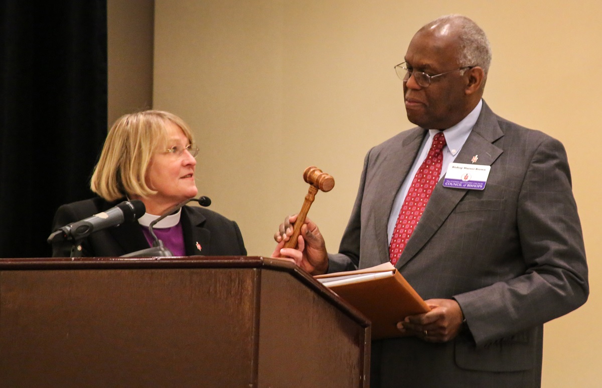 Bishop Warner H. Brown Jr., the new president of the Council of Bishops, accepts the gavel from Bishop Rosemarie Wenner in a ceremony Nov. 3 in Oklahoma City. Photo by Andrew Jensen, United Methodist Communications
