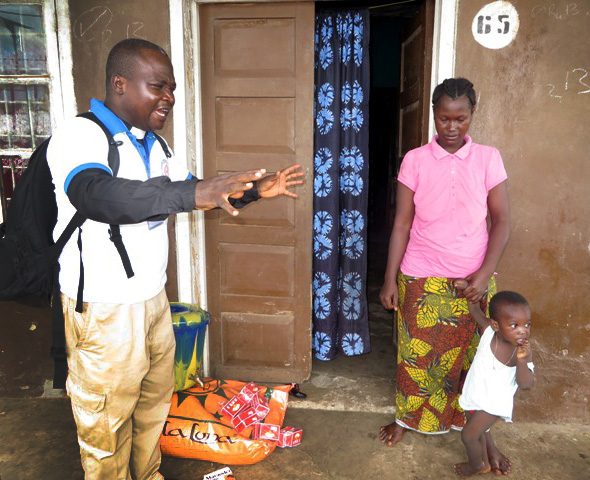 The Rev Sylvester Holima prays with Hawa Bockarie, bereaved wife of the Rev. Samuel Bockarie, who died of Ebola. He prays for God's strength and provision for the family.