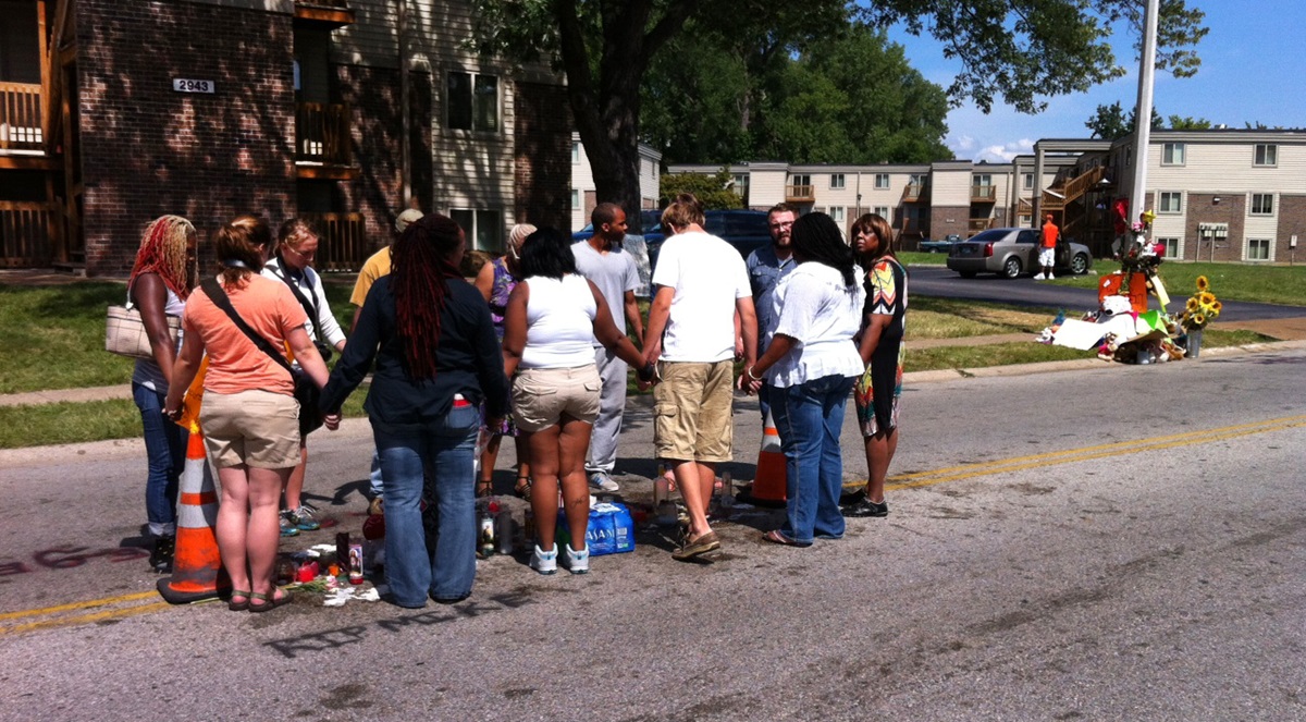 People hold hands and pray during an August vigil near the site where Michael Brown was killed in Ferguson, Mo. Photo by Matt Miofsky