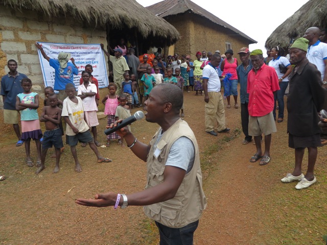 The Rev. Michael Gbenday gives an educational program about Ebola in Mende, the local language of the people of Moyollo village in Sierra Leone. Photo by Phileas Jusu, UMNS