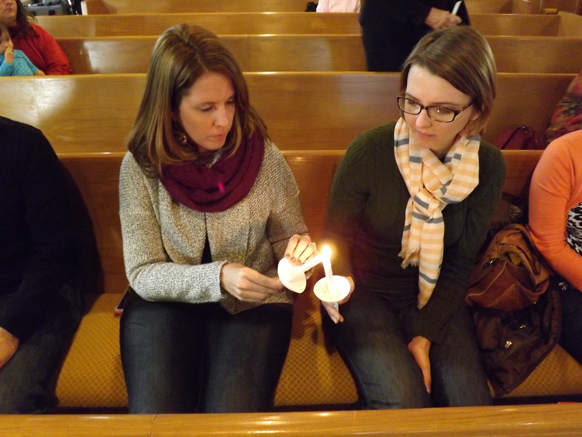 Nicole Hornbaker (left) and Megan Griffiths attend a prayer service for Dr. Martin Salia at Hanscom Park United Methodist Church in Omaha, Neb., Nov. 16. Salia, chief medical officer and surgeon at United Methodist Kissy Hospital in Freetown, Sierra Leone, died at Nebraska Medical Center Nov. 17 from Ebola. 