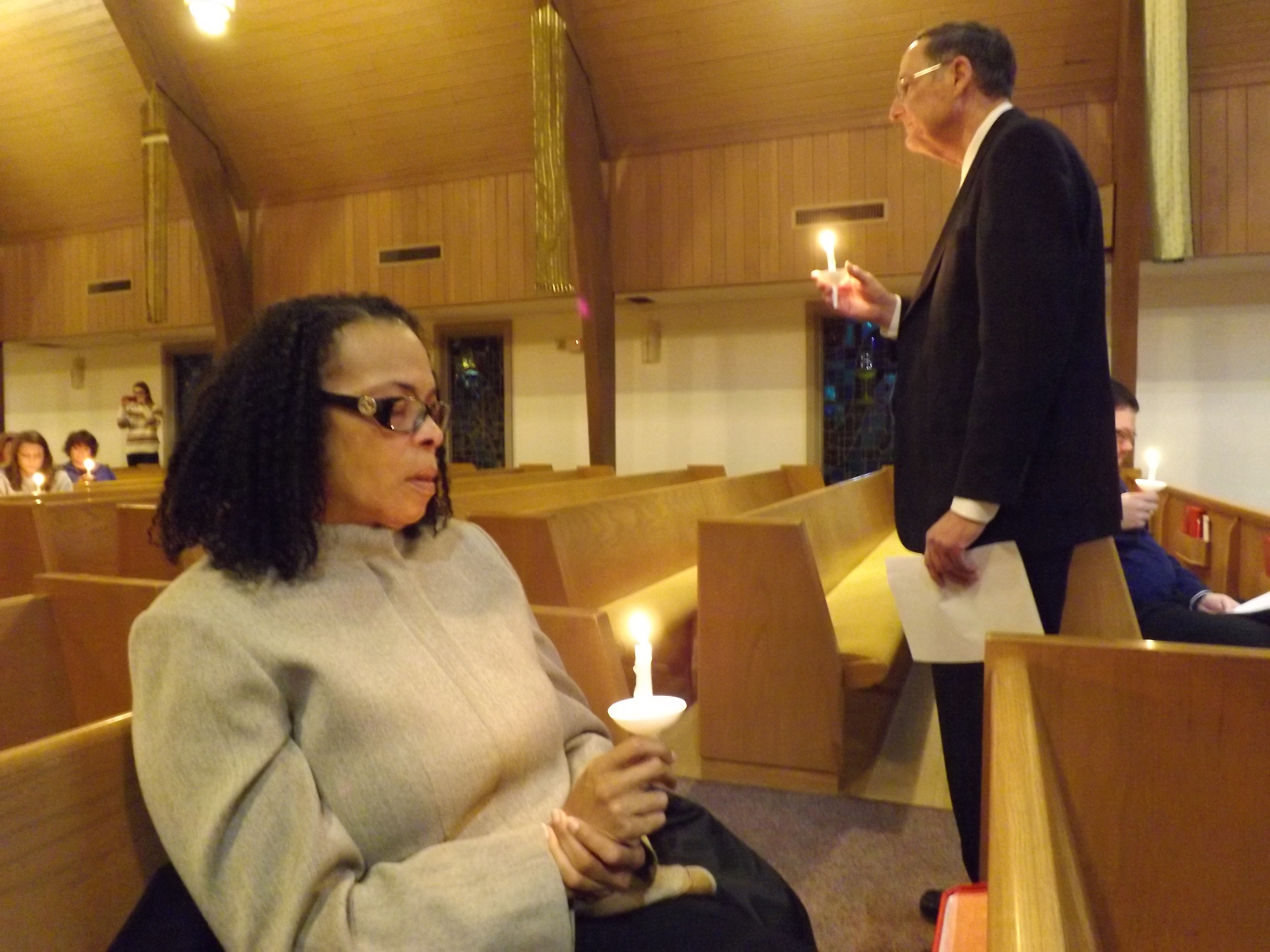 The Rev. Dan Flanagan (standing) helps lead a prayer service for Dr. Martin Salia at Hanscom Park United Methodist Church in Omaha, Neb., Nov. 16. Salia, chief medical officer and surgeon at United Methodist Kissy Hospital in Freetown, Sierra Leone, died at Nebraska Medical Center Nov. 17 from Ebola. Seated is the Rev. Portia Cavitt. 