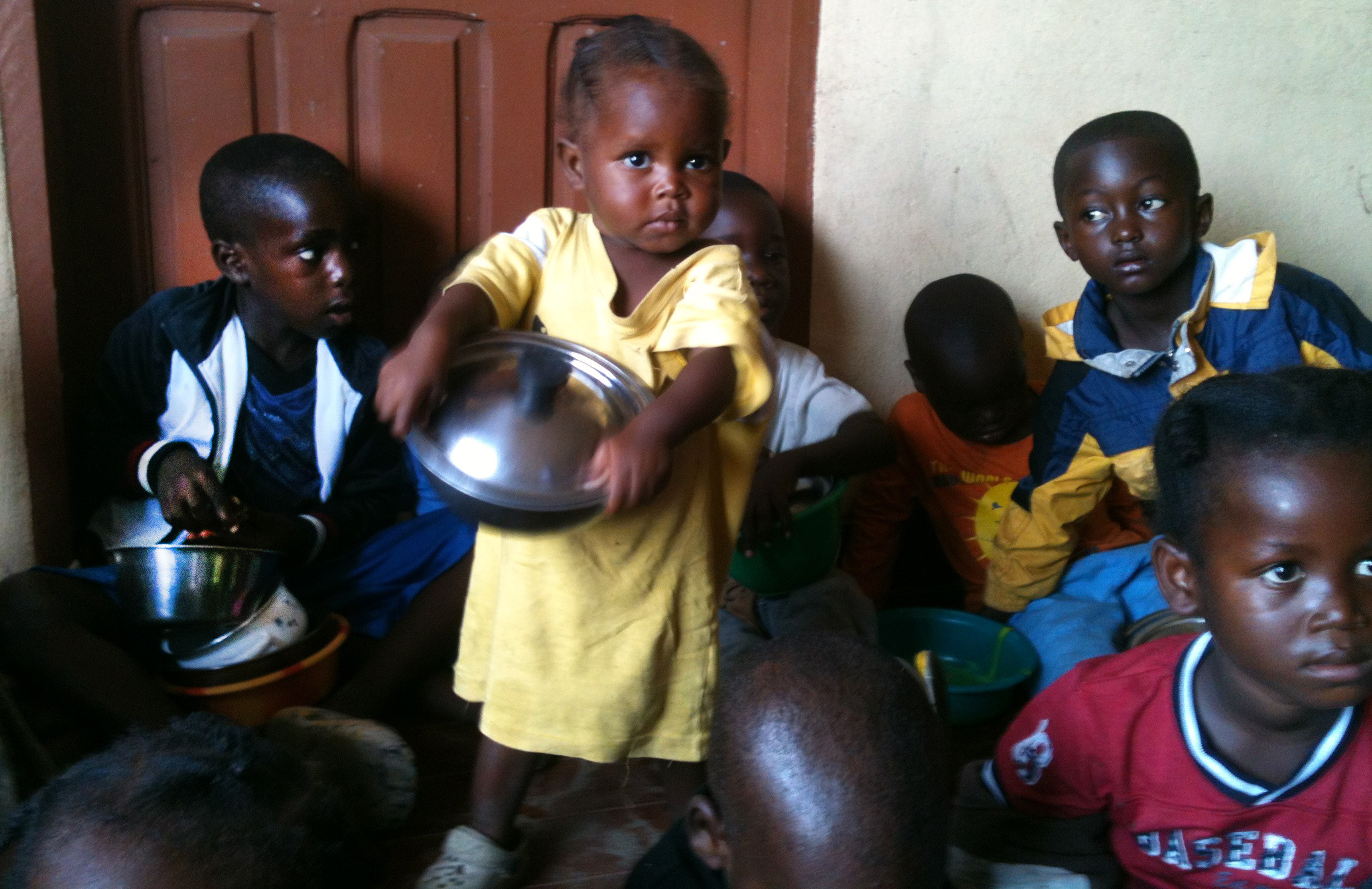Children hold bowls of food served by a feeding initiative created by a United Methodist pastor to feed Ebola orphans and those quarantined during the Ebola crisis. Hundreds of children are fed in the slum community of West Point in Monrovia. 