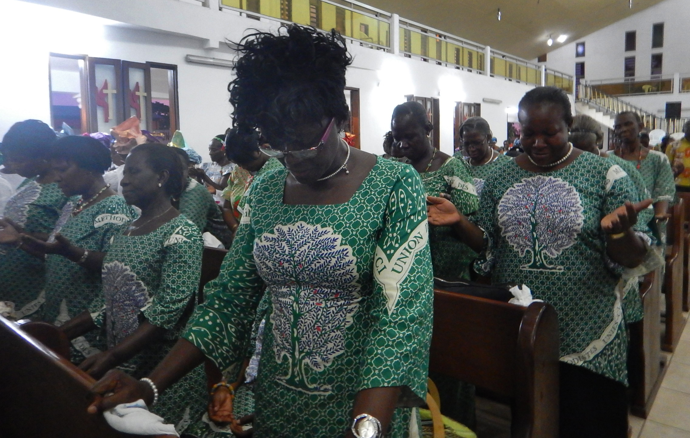 Côte d’Ivoire United Methodist Women bow their heads in prayer at a service celebration the women’s partnership with the social media network Pubcell CI. Photo by Isaac Broune, UMNS
