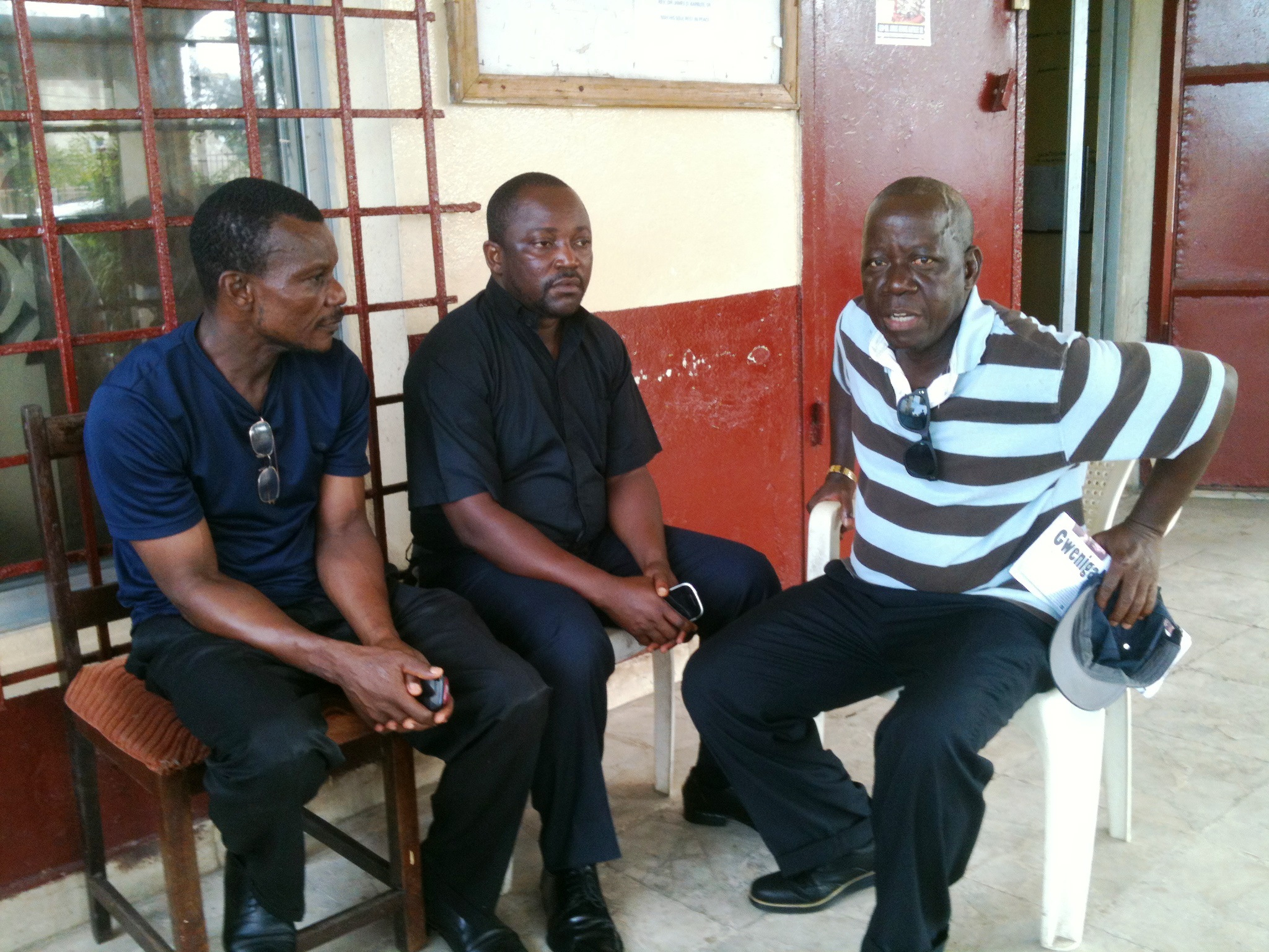 The Rev. P. Harvey Willie, superintendent of the Gbarnga district, talks with two United Methodist clergymen about the Ebola outbreak in Liberia. Willie, center, is shown with the Rev. Boye Davis, left, an instructor at the Gbarnga School of Theology, and the Rev. David Bondo, Jorkoleh district superintendent. UMNS photo by Julu Swen 