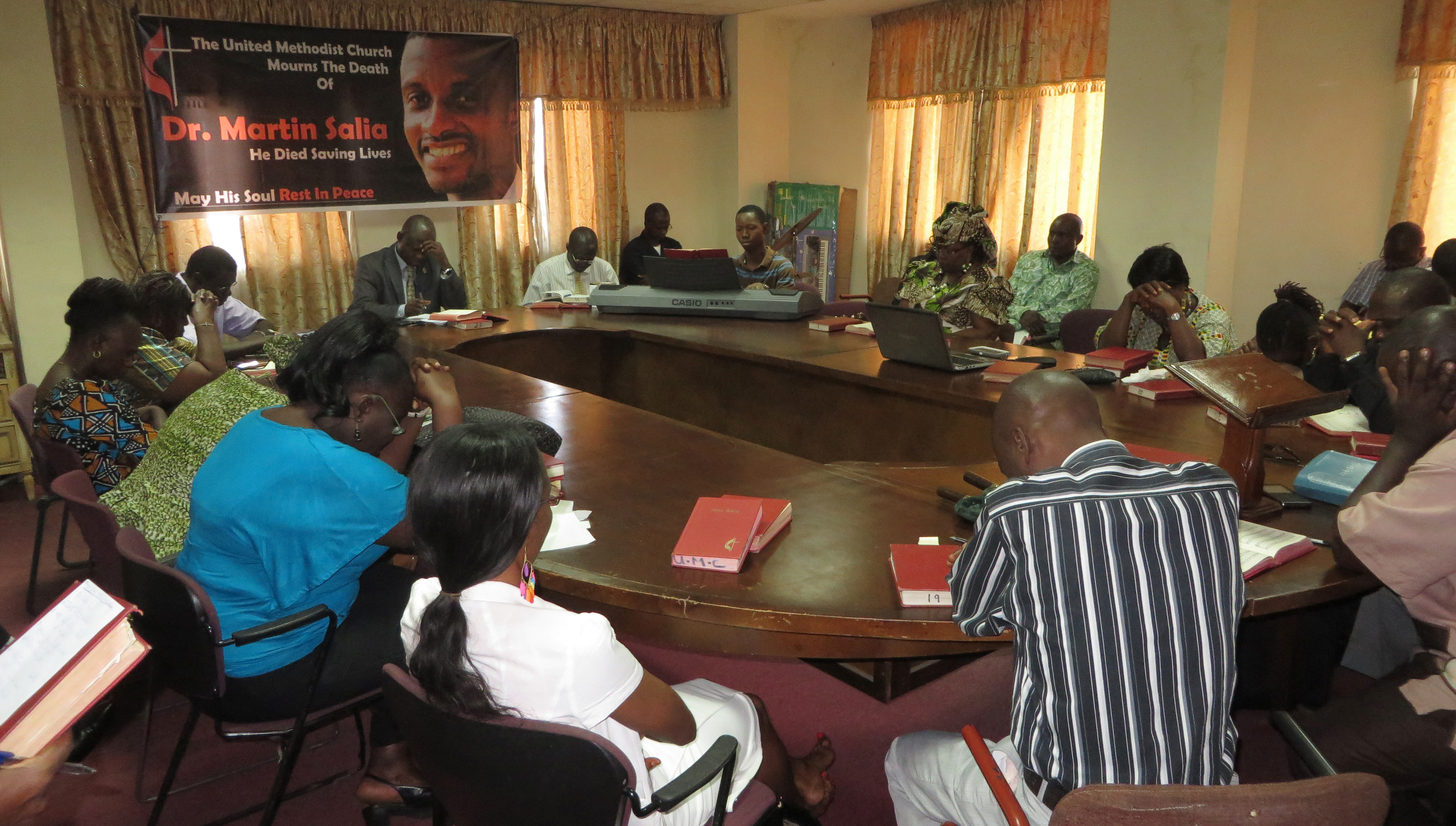 Staff members of the Sierra Leone Conference pray for Dr. Martin Salia during devotions on Nov. 19, 2014, in Freetown. Photo by Phileas Jusu, UMNS