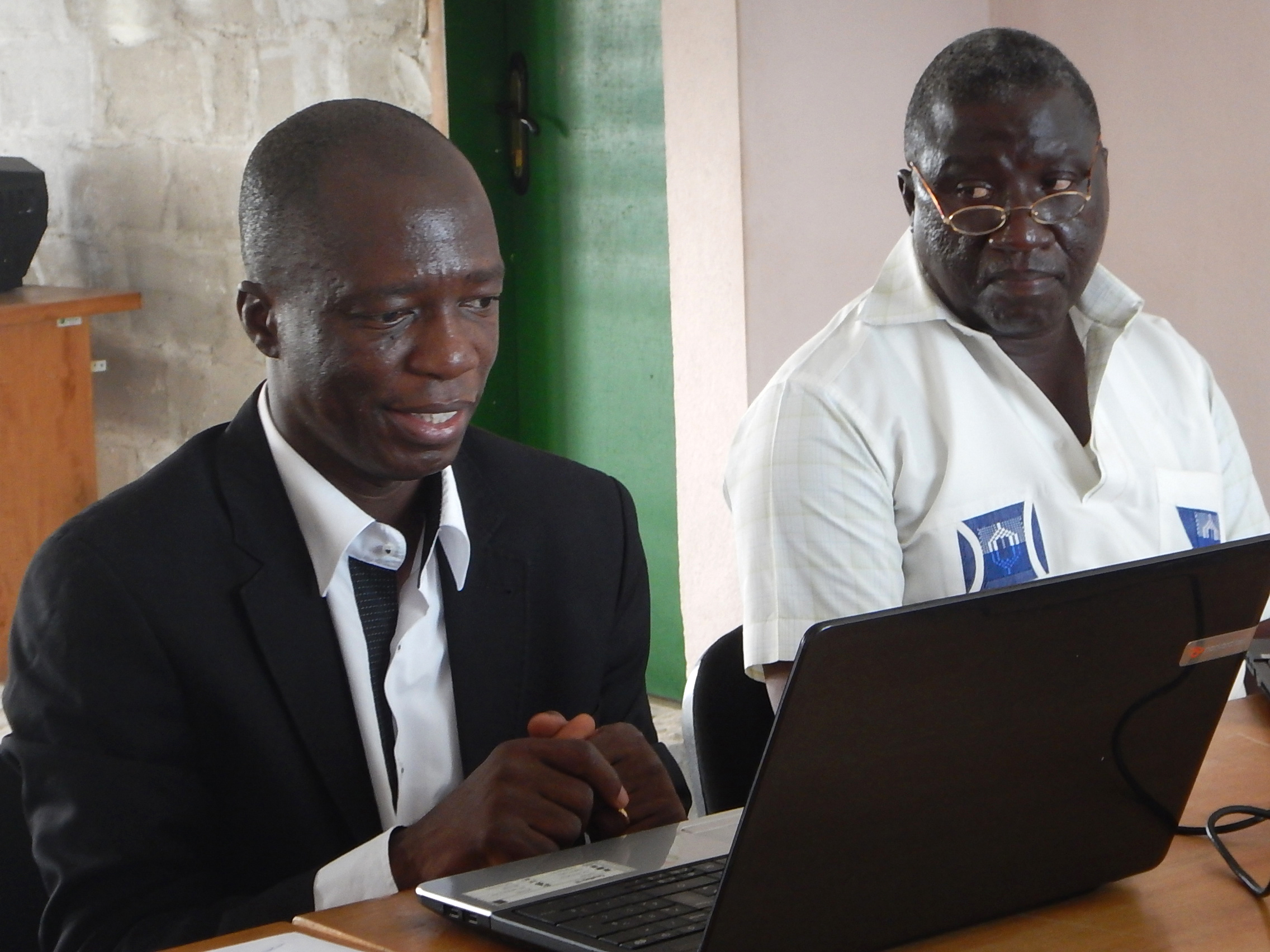 Ehui Eboua, infectious and tropical diseases specialist, displays his PowerPoint while teaching the staff of the Voice of Hope Radio about the Ebola threat. Seated next to him is M. Hyacinthe Besse, Côte d’Ivoire United Methodist Health Board’s coordinator. Photo by Isaac Broune, UMNS