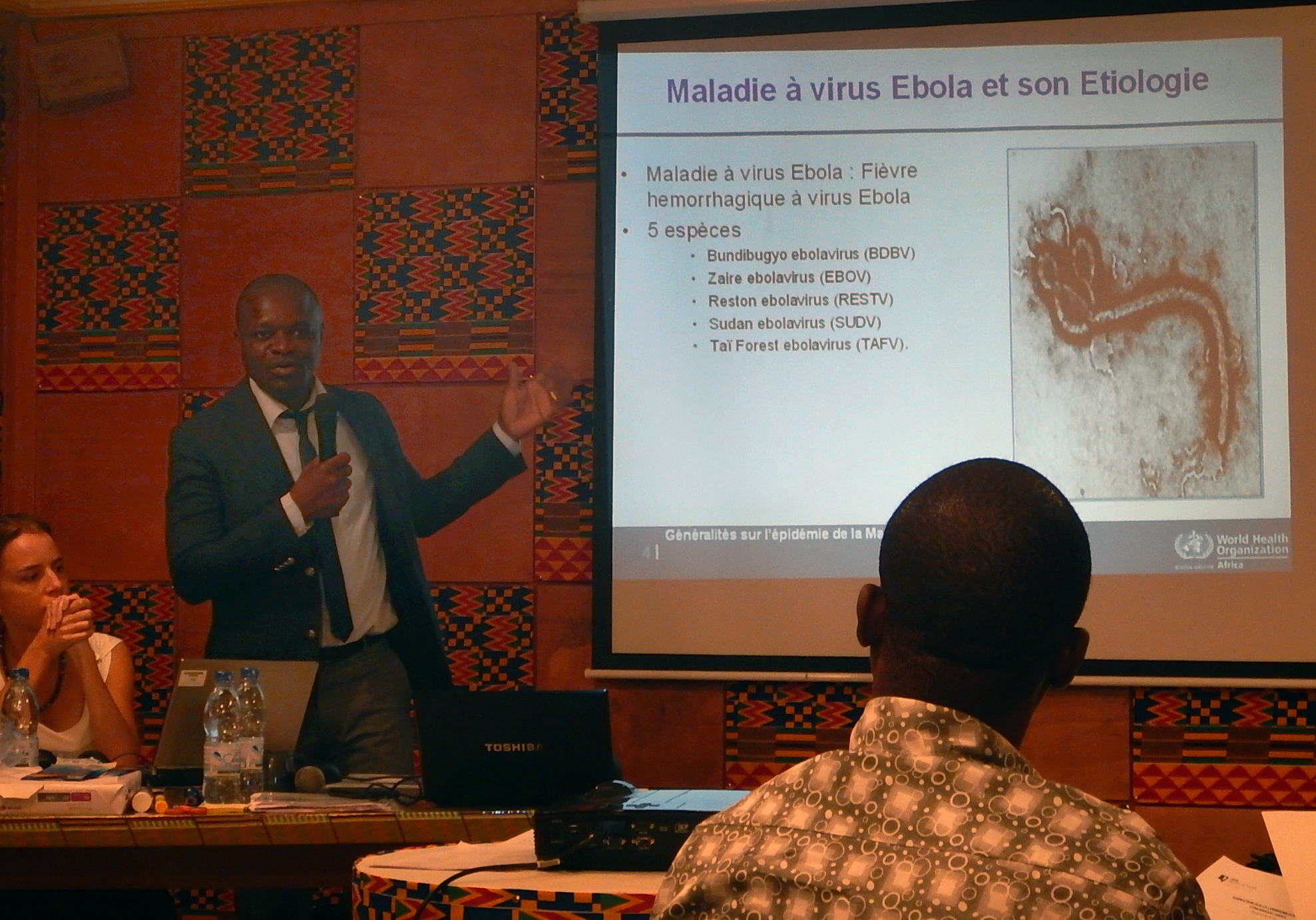 World Health Organization’s Dr. Anderson Lath speaks during a BBC Media Action workshop in emergency communication, Nov. 26-27, in Abidjan. On the screen is an enlargement of the Ebola virus. Photo by Isaac Broune, UMNS