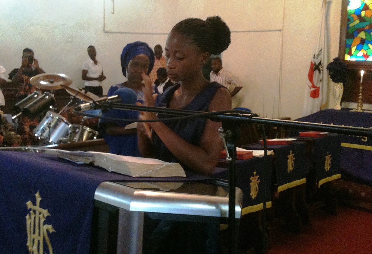 Love W. Voker signs the gospel message during the program of United Methodist StudentDay at Stephen Trowen Nagbe United Methodist Church in Monrovia, Liberia. The church distributed food and other items to the physically challenged and their families. Photo by Julu Swen, UMNS