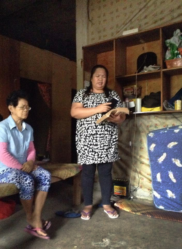 The Rev. Sharon May Aradanas, right, leads worship on Dec. 7 for church members taking refuge from Typhoon Hagupit in the Philippines. Photo courtesy of  Gladys Mangiduyos, UMNS