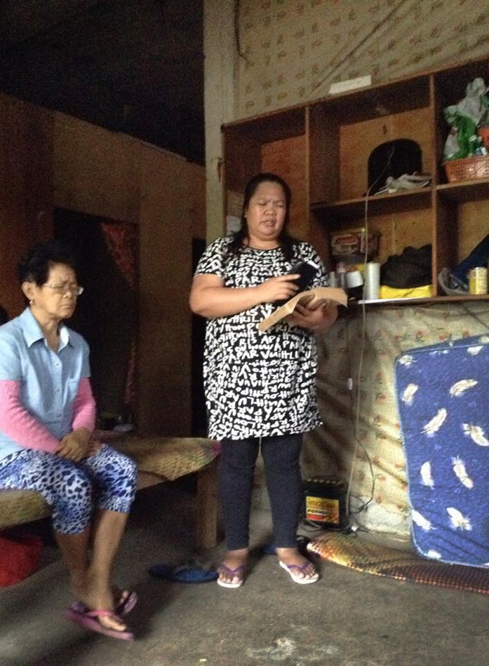 The Rev. Sharon May Aradanas, right, leads worship on Dec. 7 for church members taking refuge from Typhoon Hagupit in the Philippines. Photo courtesy of  Gladys Mangiduyos, UMNS