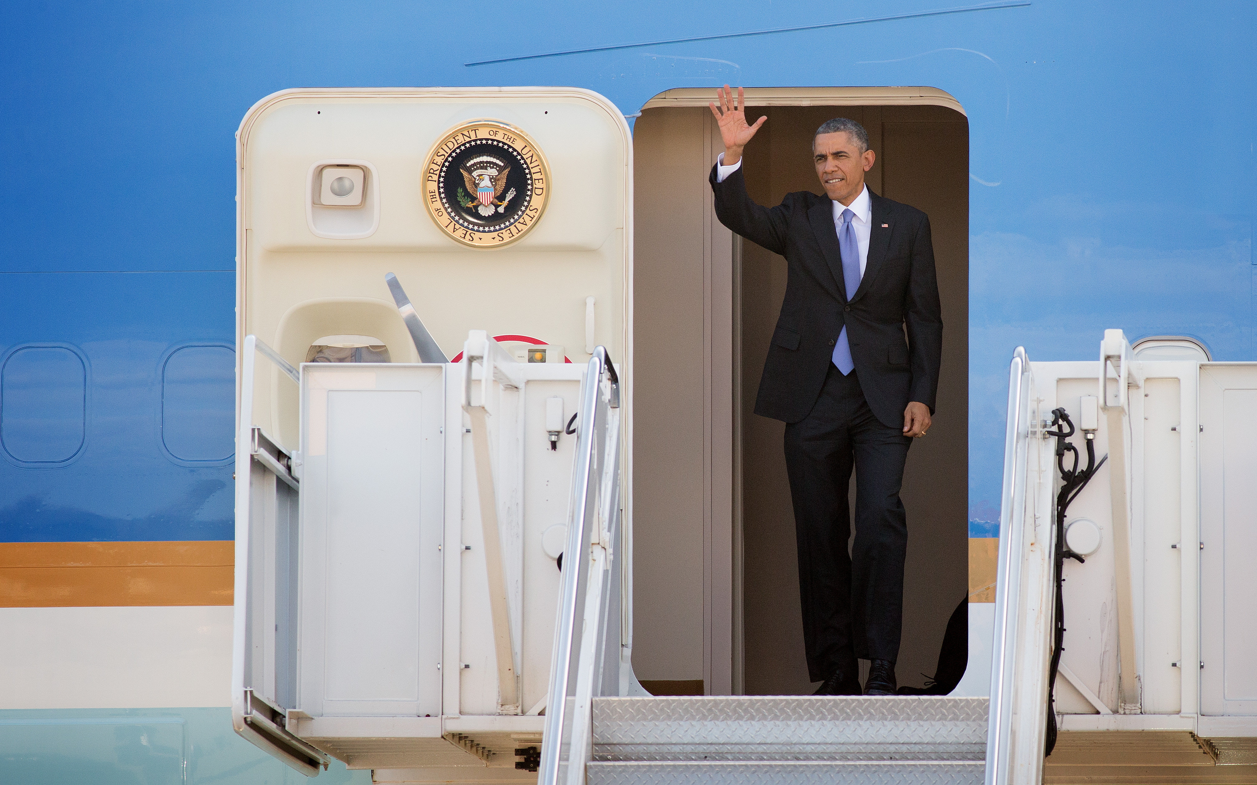 President Obama greets supporters from the doorway of Air Force One upon his arrival at Berry Field Air National Guard Base in Nashville, Tennessee. Obama spoke about his recent executive actions on immigration at Casa Azafrán, an immigrant community center. 