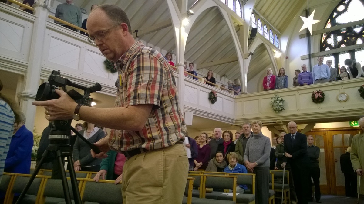 Steven Benson, an Anglican priest and TV producer, shoots video of the congregation at Knutsford Methodist Church in Cheshire, England, to share with the United Methodist Erlöserkirche (Church of the Redeemer) in Bremen, Germany, on Christmas Eve. Photo by Kathleen LaCameraUMNS