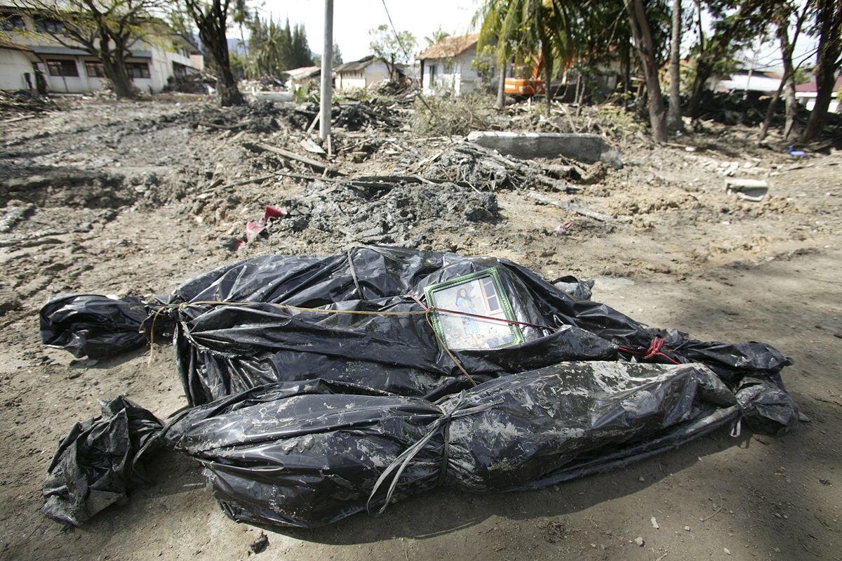 Bodies of three victims of the Dec. 26 tsunami await burial in Banda Aceh, Indonesia. One of the bundles has a photo of a girl tied to it. Three weeks after the tsunami, a delegation of mission and communications leaders of the United Methodist Church visited areas of Sumatra, Indonesia, near the epicenter of the earthquake that triggered the waves. Photo by Mike DuBose, United Methodist News Service