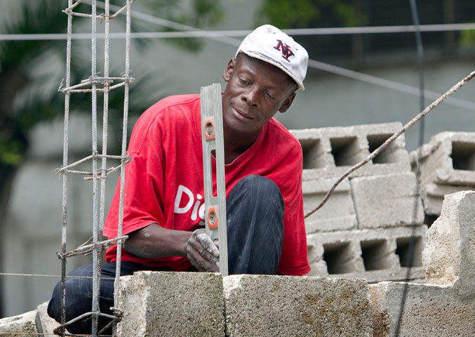 Pierre Michel repairs a wall outside the Methodist Guest House in Port-au-Prince.