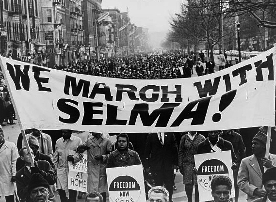 Marchers carrying a banner lead 15,000 in Harlem on March 15, 1965.  Photo by Stanley Wolfson, Library of Congress