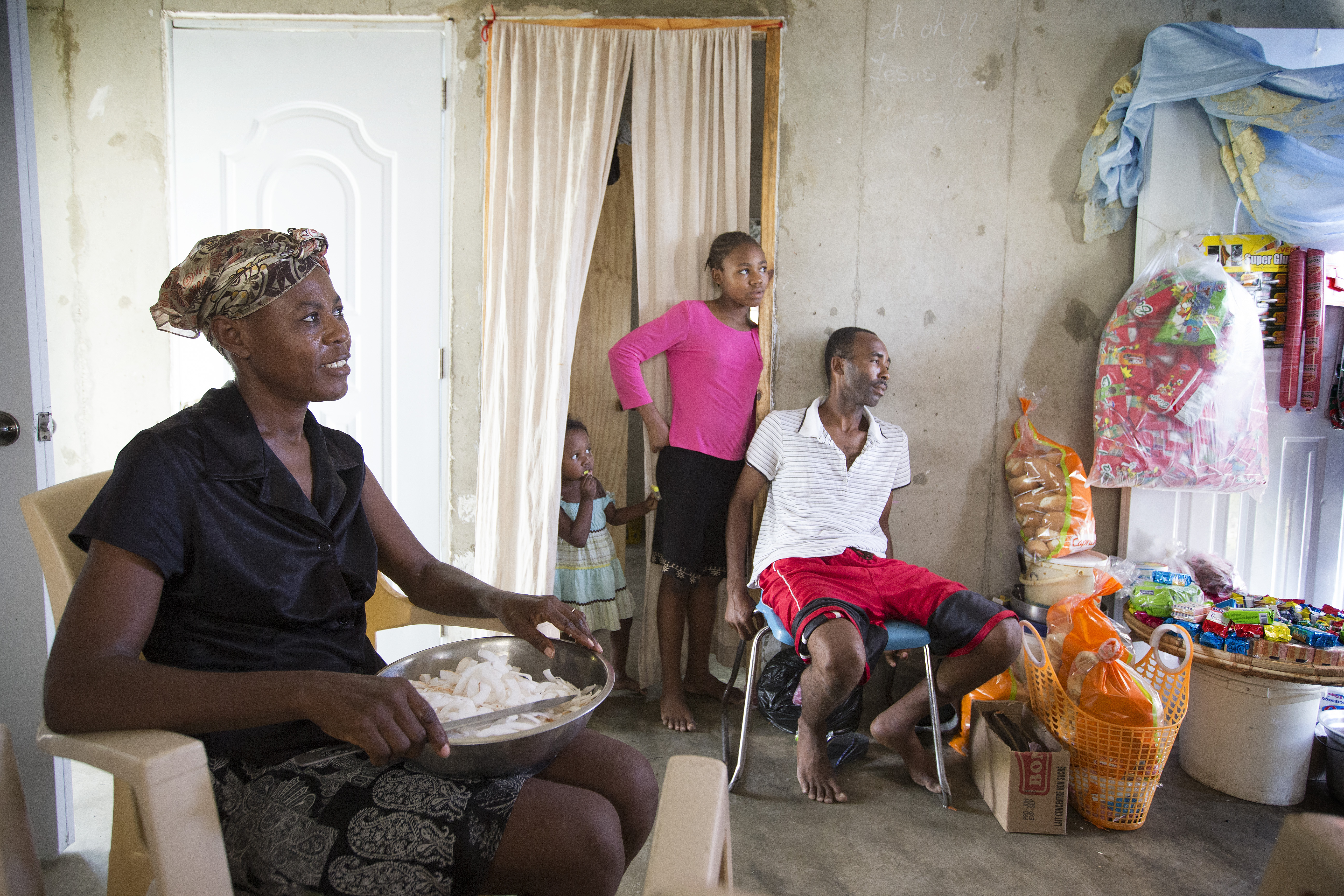 Elisma Cléance (left) and her husband Adma Alicié (right) sell food items and other household goods from the new home they share with their family near Cabaret, Haiti. They are beneficiaries of a neighborhood-based resettlement program implemented by the United Methodist Committee on Relief and the United States Agency for International Development. Photo by Mike DuBose, UMNS