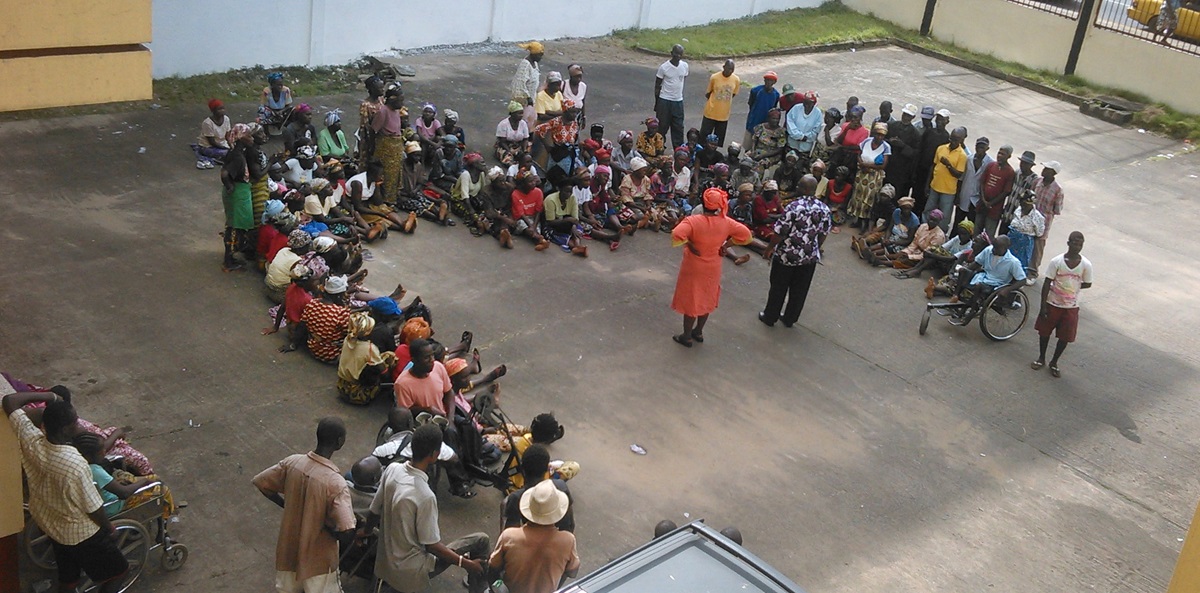 The Rev. Anna Kpaan addresses the elderly who have come to receive a distribution of rice from The Liberia Annual Conference, through its Ministry to the Aging. Photo by Nyamah Dunbar, UMNS