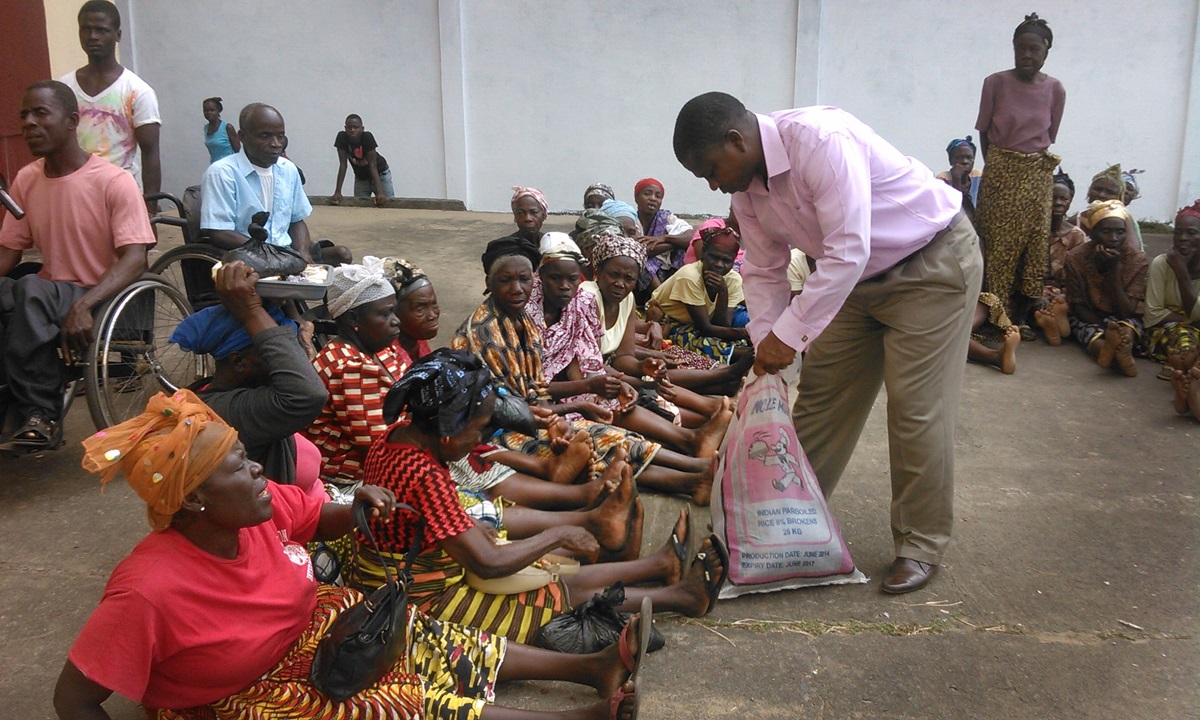 The Rev. Jerry Kandea  measures out rice for the elderly at the conference food distribution. The Liberia Annual Conference, through its Ministry to the Aging, headed by the Rev. Anna S. Kpaan, has been catering for the needs of the poor and elderly since its inception in 2005. Photo  by Nyamah Dunbar, UMNS