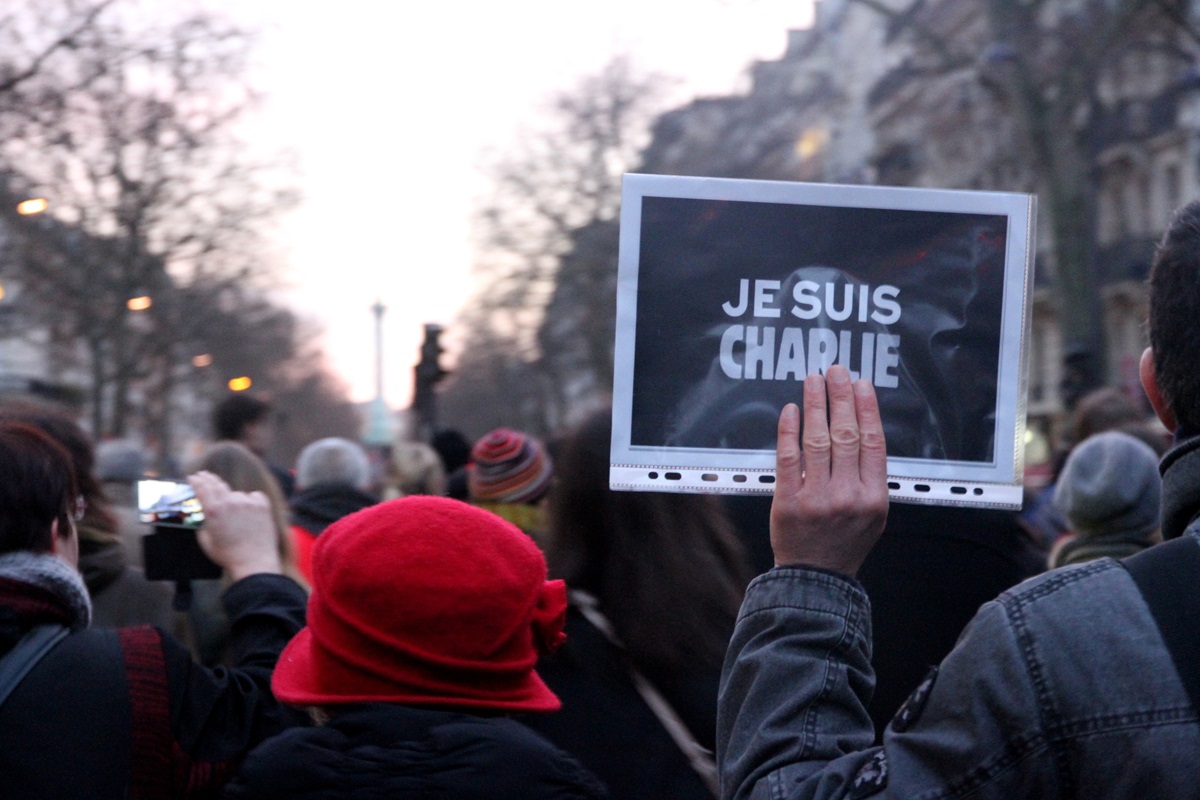 Parisians gather in solidarity holding signs reading, “Je suis Charlie.” Photo by Maya-Anaïs Yataghène, flickr creative commons. 
