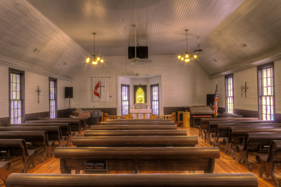 Wooden pews, heart pine floors and colored window panes are among the interior features of Fields Chapel United Methodist Church. Photo by Scott MacInnis, courtesy Historic Rural Churches of Georgia.