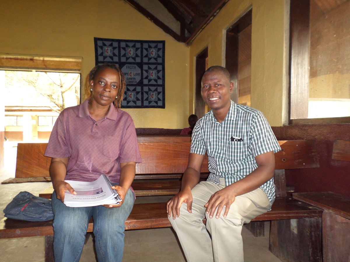 Victor Doolakeh Taryor chats with Nora Keah, who will serve as interim administrator at Ganta United Methodist Hospital after Taryor’s departure. Photo by Julu Swen, UMNS