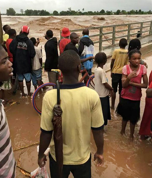 People in watch as flood waters rise dangerously high in Mozambique.  Photo by Quari Ziyaad Patel 