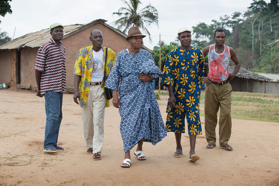 Chief André Djirika Djeli (center) and village elders walk through the fishing community of Monogaga.