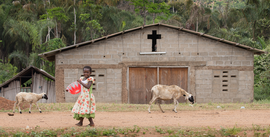 A young girl shares the road with passing goats in the fishing community of Monogaga.