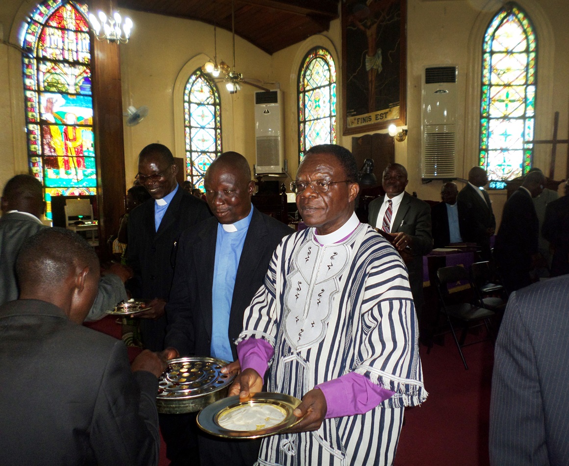 Bishop John G. Innis distributes Holy Communion at First United Methodist Church in Monrovia during a special service that marked his return from the United States, where he stayed for months for health reasons and restrictions due to the Ebola crisis.  Photo by Julu Swen, UMNS 