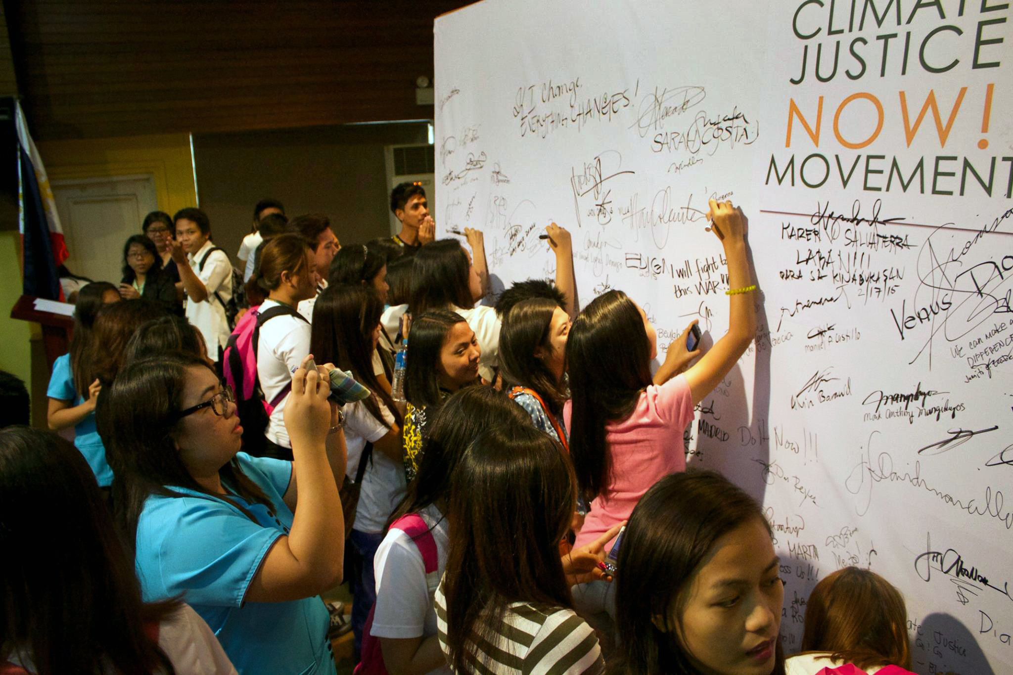 About 300 students, faculty, staff and guests join the Climate Justice Now! movement by signing their names during a forum held in Cabanatuan City at Wesleyan University-Philippines.  Photo by Gladys Mangiduyos