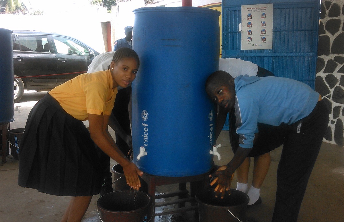 Students at J.J. Roberts United Methodist School in Liberia use one of the large hand-washing stations in this file photo from March 2015. School opened in March after being closed for months due to Ebola. File photo by Nyamah Dunbar, UMNS