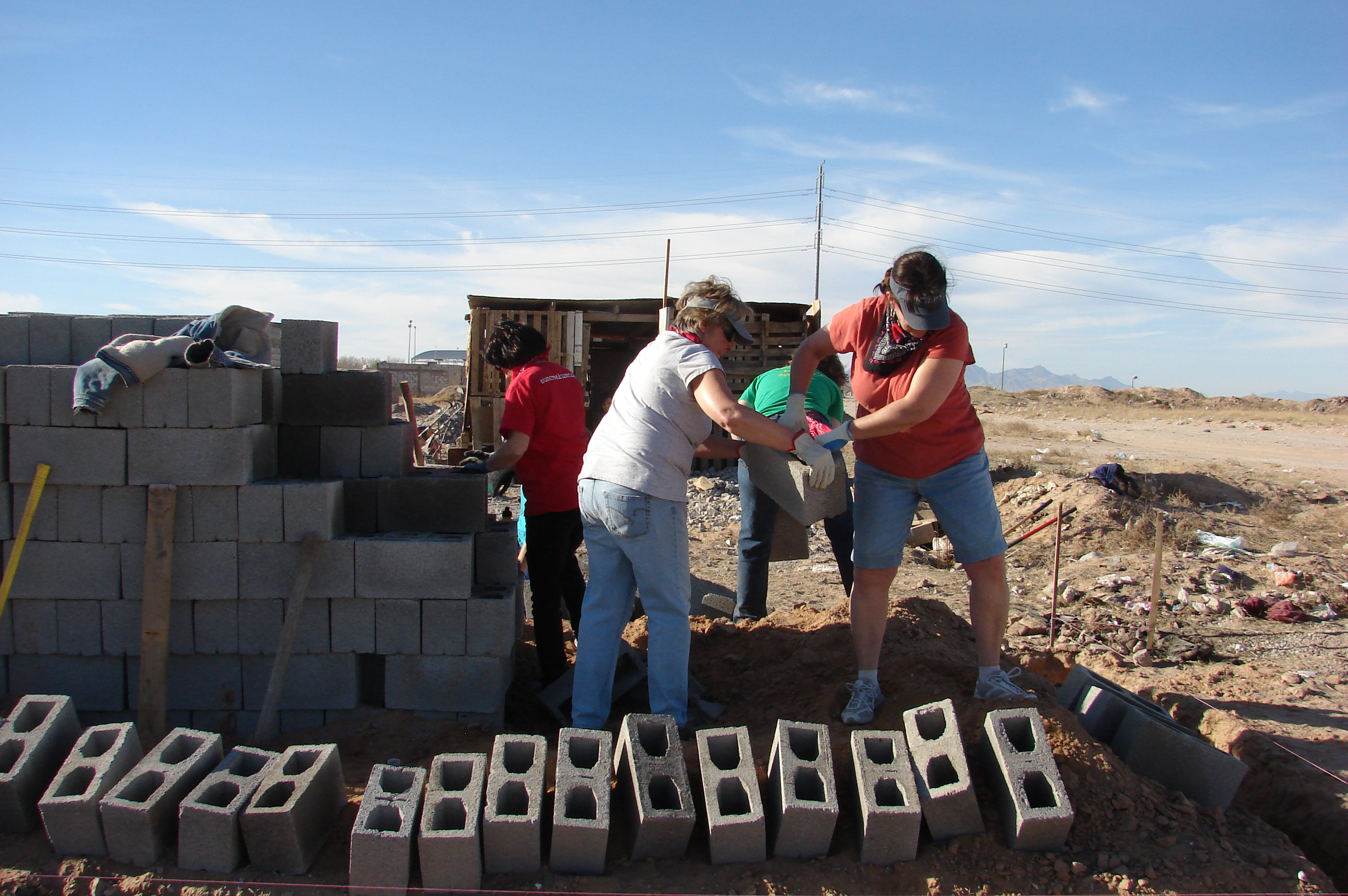 Dawn Moneyheffer (left) and Rita Thomas handle cinder blocks while helping the Suncreek United Methodist Church mission team build a home last month for a needy family in Ciudad Juárez, Mexico. Photo by Sam Hodges, UMNS 