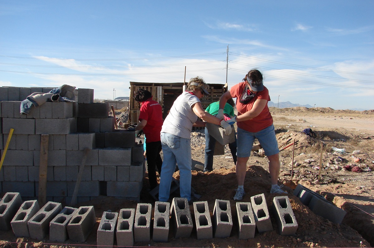 Dawn Moneyheffer (left) and Rita Thomas handle cinder blocks while helping the Suncreek United Methodist Church mission team build a home last month for a needy family in Ciudad Juárez, Mexico. Photo by Sam Hodges, UMNS 