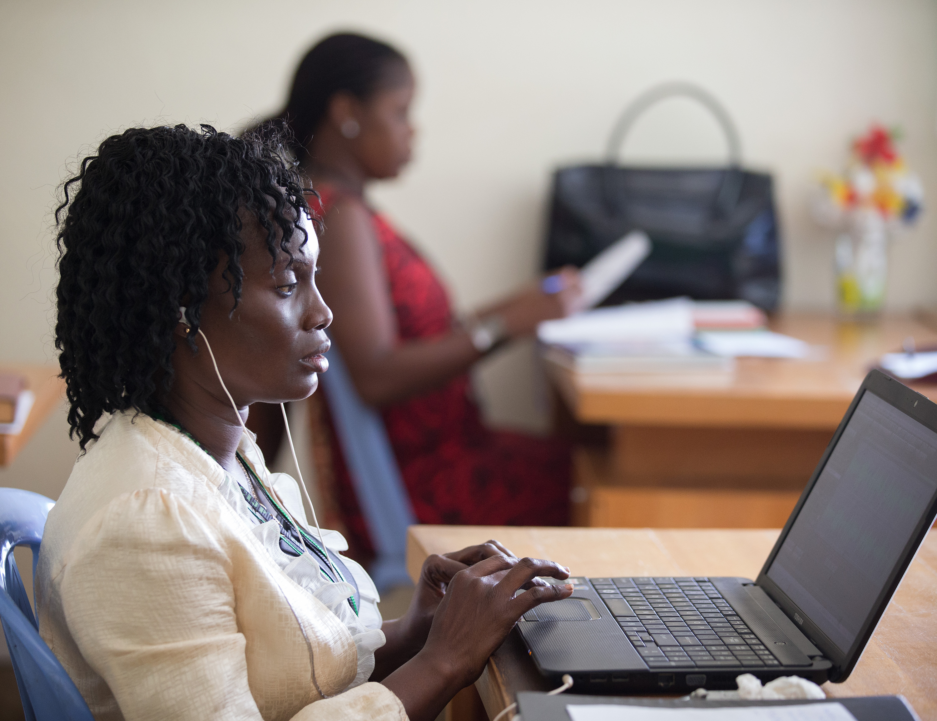 Patricia Ohomon (foreground) edits a story in the newsroom of The United Methodist Church's Voice of Hope radio station in Abidjan, Côte d'Ivoire. Photo by Mike DuBose, UMNS