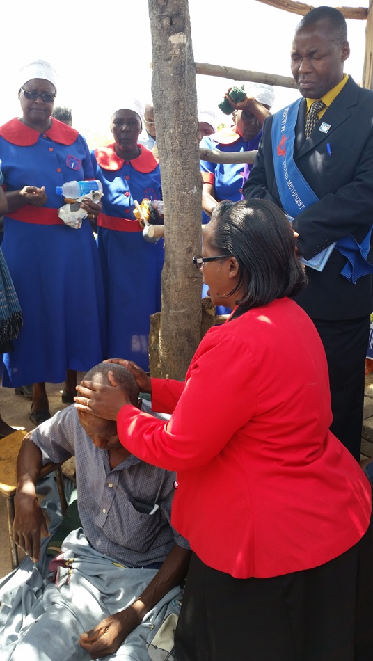 Pastor Rufaro Magomo prays for the healing of Marck Muringani who has been ill for four months. 
