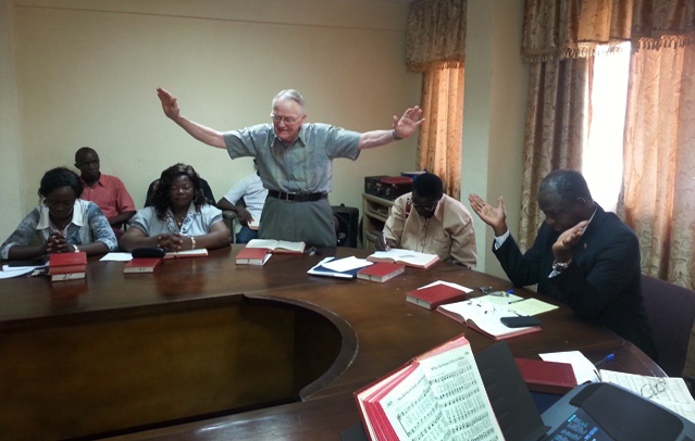 Dr. Lowell Gess prays for Sierra Leone at a weekly devotion held at the United Methodist Church house in Freetown. 