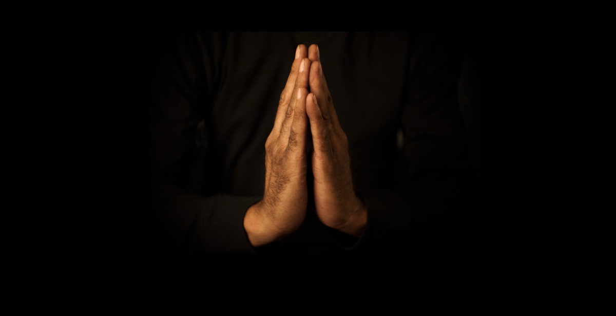 An image of hands in prayer. Photo illustration by Mike DuBose, UMNS.