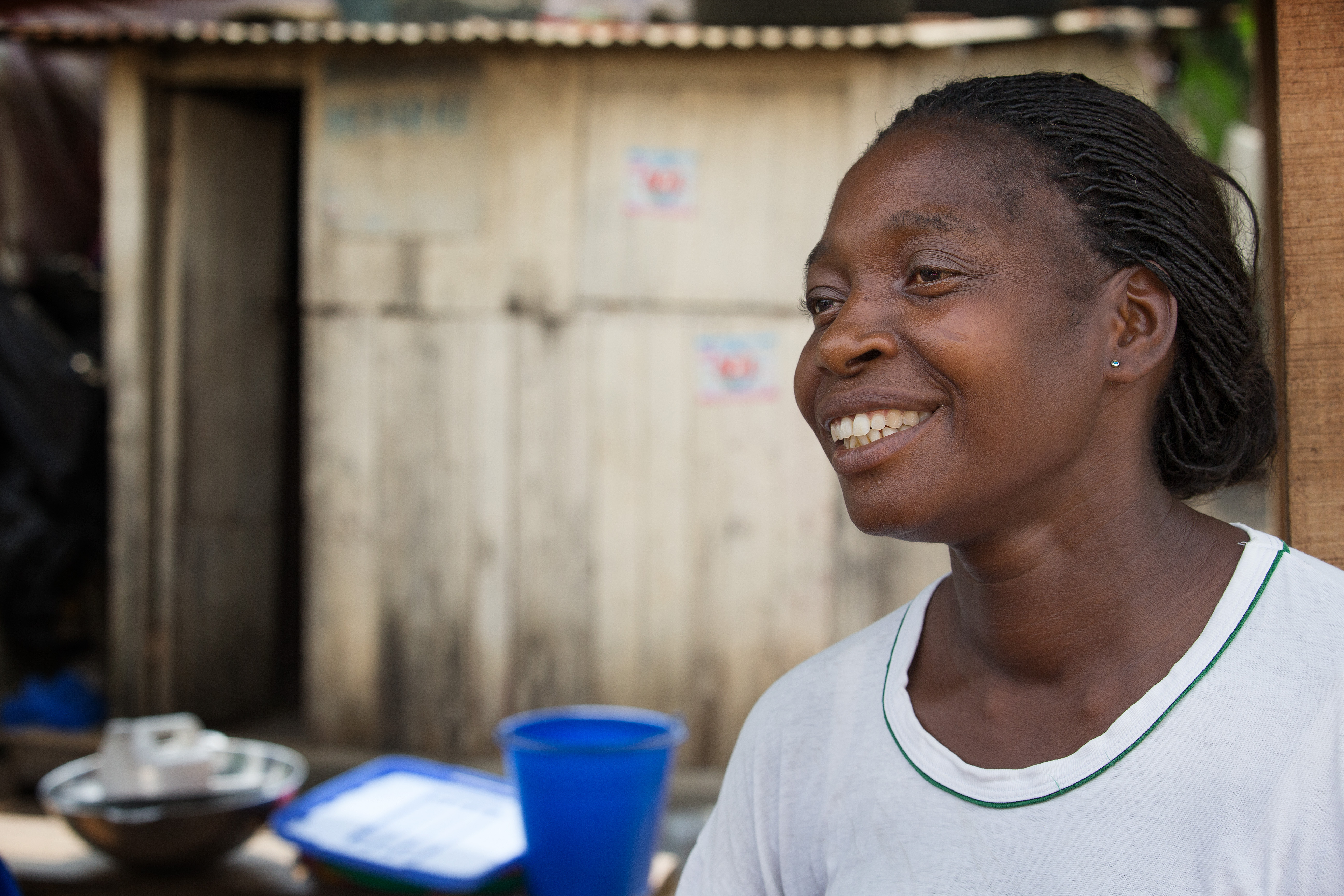 Reine Akaffou sells palm oil from a market stall in Abidjan, Côte d'Ivoire.  