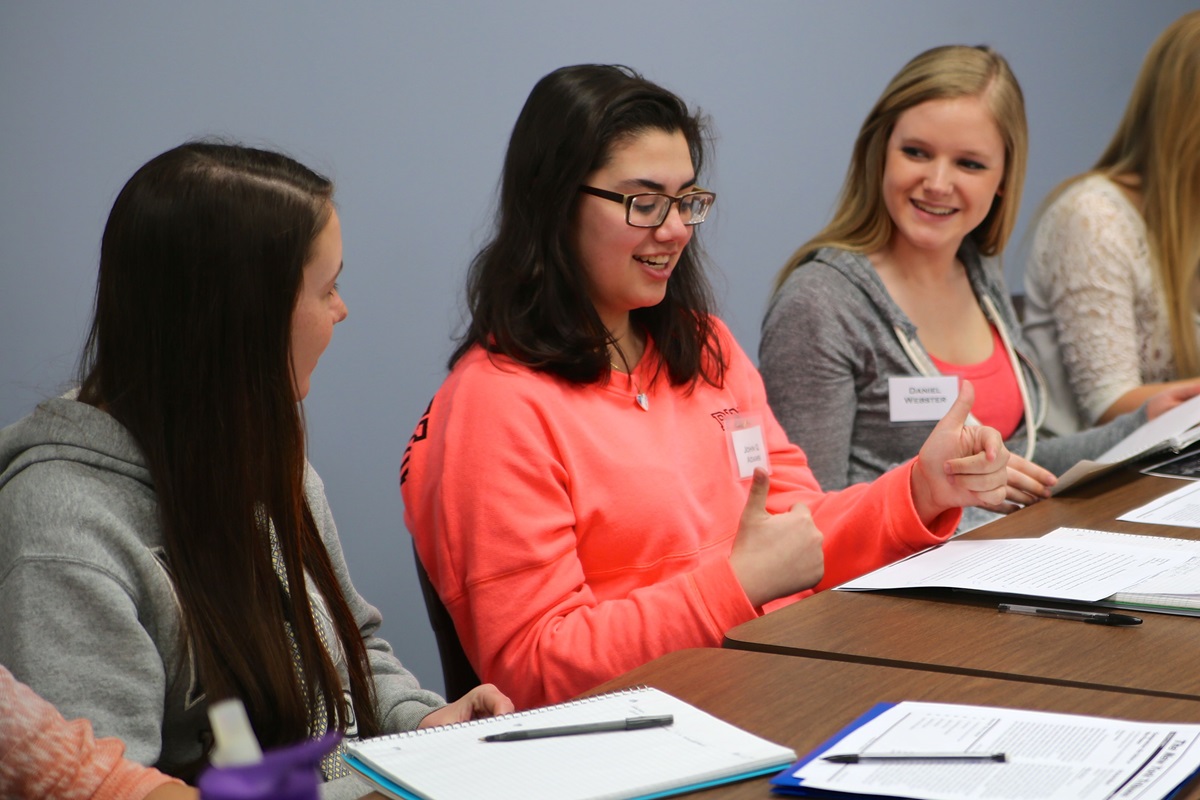 Ashley Bruce consults with her fellow students Rachel Kanaziz, left, and Kennedy Ervin, right, before presenting her argument in “The Fredrick Douglass Game” at Adrian College. Photo by Mike Neal