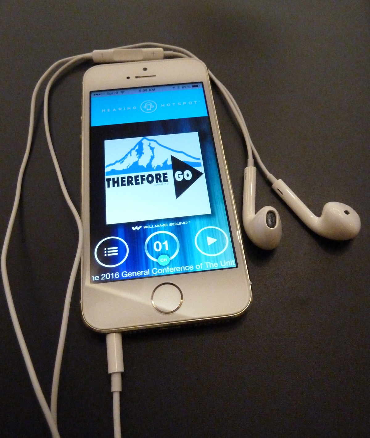 A smart phone displays the logo “Therefore Go” used for the United Methodist General Conference 2016. The headphones and app could provide a “hearing hotspot” for translation into different languages.  Photo by Greg Nelson