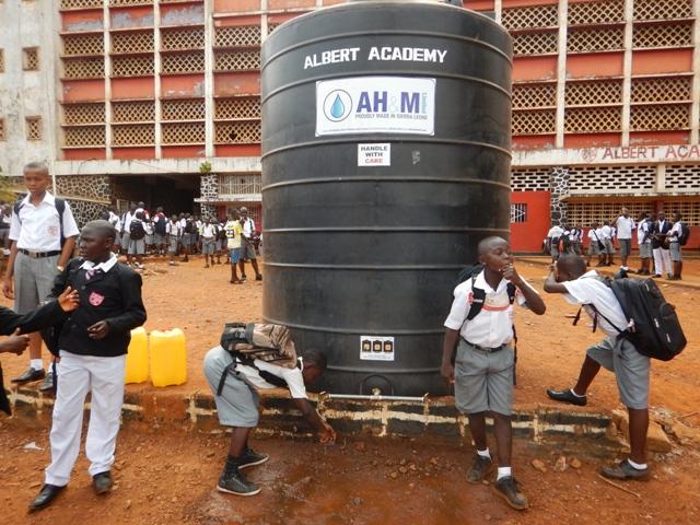 Students at the Albert Academy in Western Freetown wash hands at end of break time before going back to their classes. The Ministry of Health has provided huge water tanks in many schools which are regularly refilled so that staff and students can wash hands regularly during school hours.