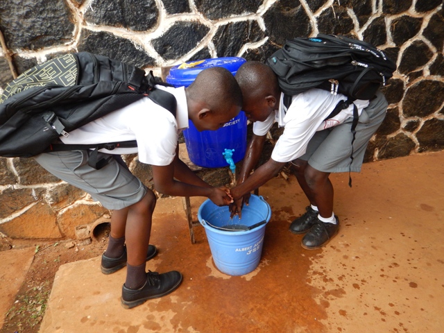 Students at the Albert Academy wash hands outside before they are allowed into their classroom. The students take hand washing seriously.
