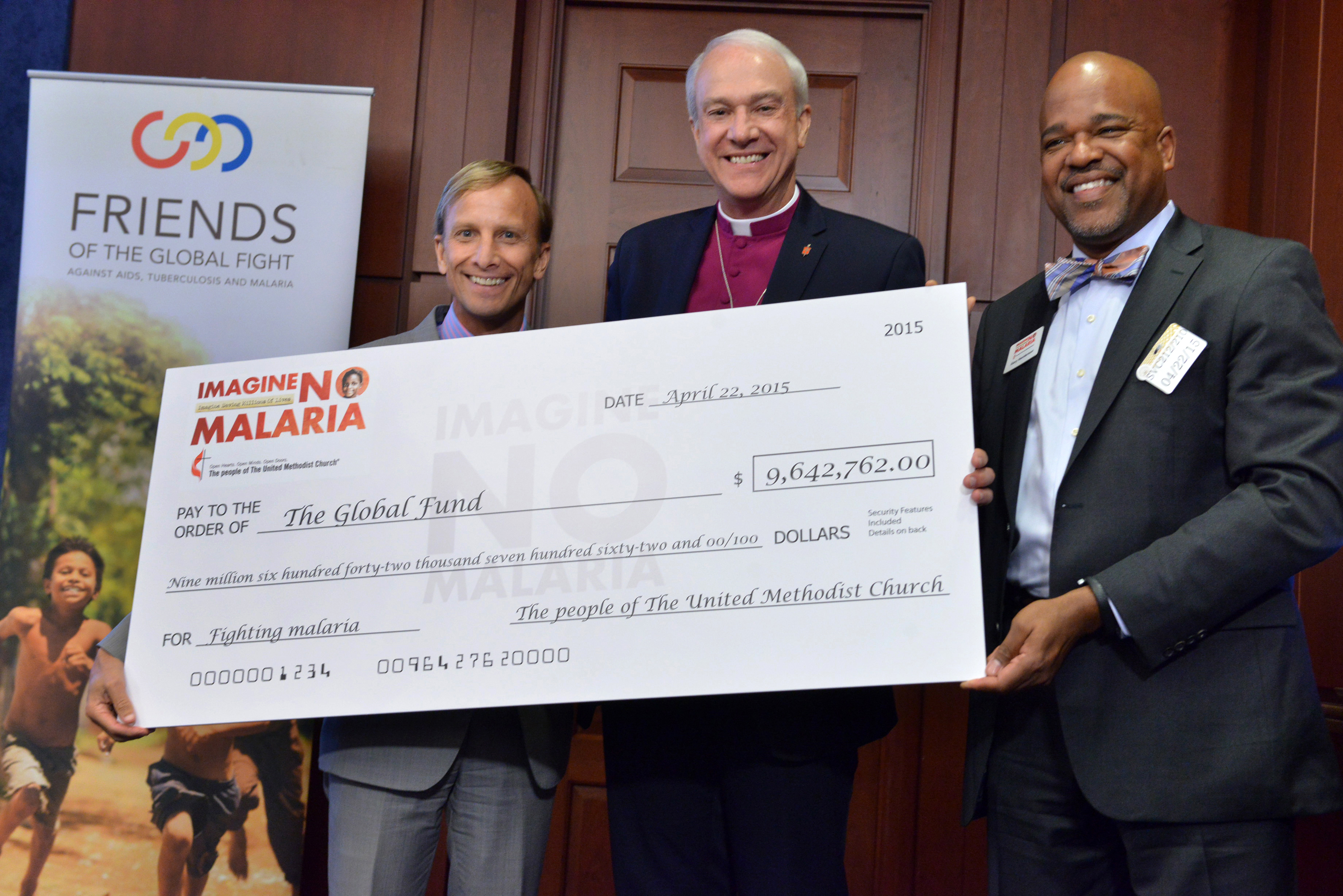 Bishop Thomas Bickerton and the Rev. Gary Henderson (right) present Dr. Mark Dybul, executive director of the Global Fund, with a gift for $9.6 million, a donation from Imagine No Malaria, an initiative of the people of The United Methodist Church to eliminate malaria deaths. Photo by Jay Mallin, UMNS
